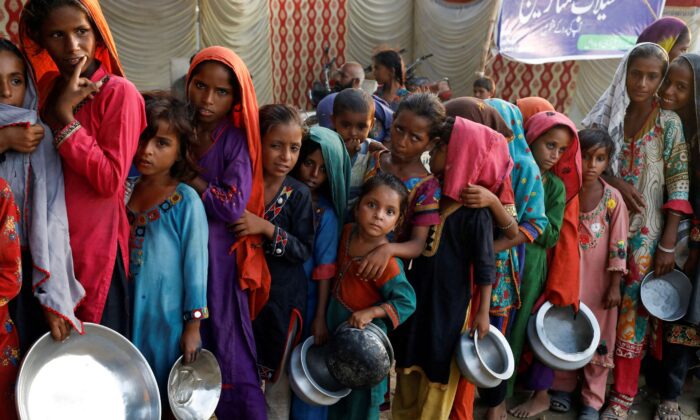 Жертвы наводнений собираются в лагере, чтобы получить продовольственную помощь после дождей и наводнений в сезон муссонов в Сехване, Пакистан, 14 сентября 2022 года. (Akhtar Soomro/Reuters) | Epoch Times Россия
