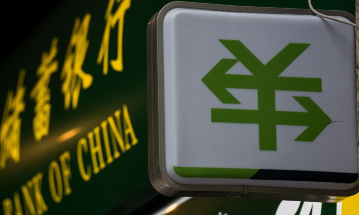 Знак валюты китайского юаня с двумя стрелками изображён возле банковского отделения Народного банка Китая в Шанхае 13 августа 2015 года. (Johannes Eisele/AFP via Getty Images) | Epoch Times Россия