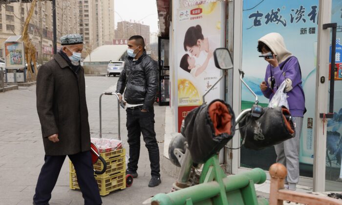 Горожане в масках идут по улицам Аксу в Синьцзяне, западный Китай, 18 марта 2021 года. (Ng Han Guan/AP Photo)
 | Epoch Times Россия
