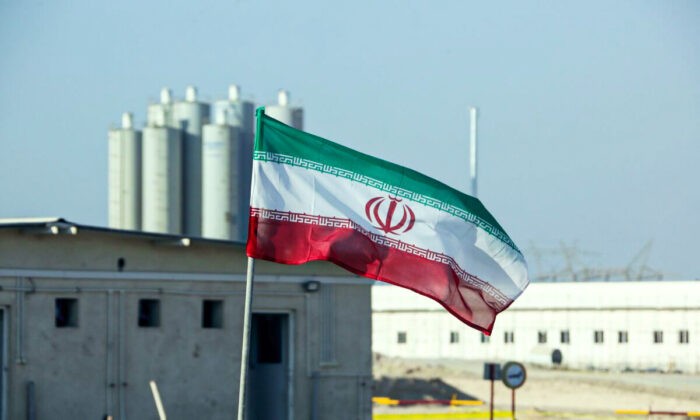Иранский флаг на Бушерской атомной электростанции Ирана во время официальной церемонии начала работ по строительству второго реактора на объекте, в Бушере, Иран, 10 ноября 2019 года. (Atta Kenare/AFP via Getty Images) | Epoch Times Россия