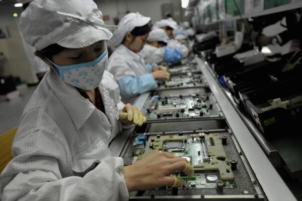 Китайские рабочие собирают электронные компоненты на заводе тайваньского технологического гиганта Foxconn в Шэньчжэне, южная провинция Гуанчжоу, 26 мая 2010 года.  (AFP/AFP via Getty Images)
