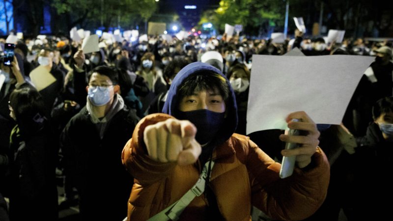 Люди держат белые листы бумаги в знак протеста в Пекине 27 ноября 2022 года. (Thomas Peter/Reuters) | Epoch Times Россия