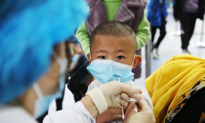 Медицинский работник делает прививку ребёнку во временном пункте вакцинации против COVID-19 в Чунцине, Китай, 3 ноября 2021 года. (Yang Min/Costfoto/Future Publishing via Getty Images) | Epoch Times Россия