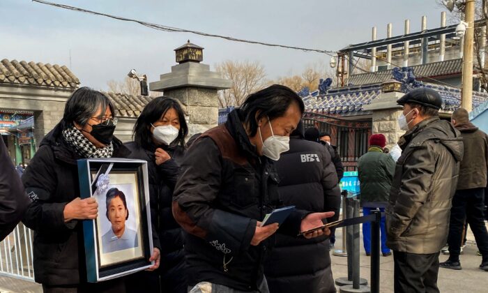 Родственники с траурным фото в крематории в Пекине 20 декабря 2022 года. (Noel Celis/AFP via Getty Images) | Epoch Times Россия