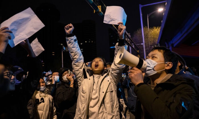 Протестующие выкрикивают лозунги во время акции протеста против строгих китайских мер «нулевой COVID», в Пекине, 28 ноября 2022 года. Фото: Kevin Frayer/Getty Images | Epoch Times Россия