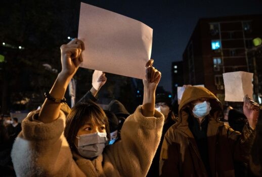 Люди держат листы бумаги, протестуя против цензуры и строгих мер Китая по борьбе с COVID, в Пекине 27 ноября 2022 года. (Kevin Frayer/Getty Images)