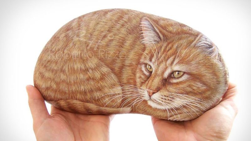 Художник рисует животных на камнях