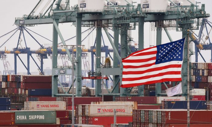 Китайские морские контейнеры рядом с флагом США в порту Лос-Анджелеса в Лонг-Бич, Калифорния, 14 мая 2019 года. Фото: Mark Ralston/AFP/Getty Images | Epoch Times Россия