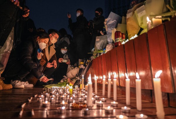 Протестующие в Пекине собрались у мемориала 27 ноября 2022 года после того, как по меньшей мере 10 человек погибли в результате пожара в многоквартирном доме в Синьцзяне, ответственность за который возлагается на ограничительные меры КПК в борьбе с COVID. (Kevin Frayer/Getty Images)