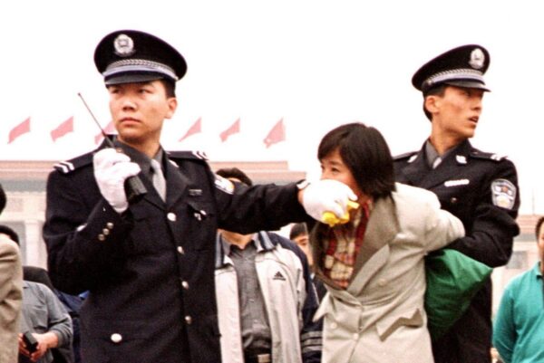 Китайские полицейские арестовывают практикующего Фалуньгун на площади Тяньаньмэнь в Пекине 10 января 2000 года. (Chien-Min Chung/AP Photo)