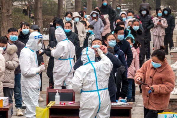 Жители стоят в очереди, чтобы пройти тесты на нуклеиновые кислоты на COVID-19 в Аньяне, провинция Хэнань, центральный Китай, 26 января 2022 года. (STR/AFP via Getty Images)