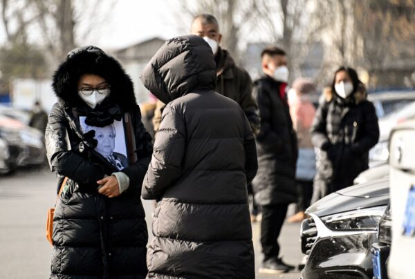 Женщина держит рамку с изображением близкого человека в крематории в Пекине, 20 декабря 2022 года. (Noel Celis/AFP via Getty Images)