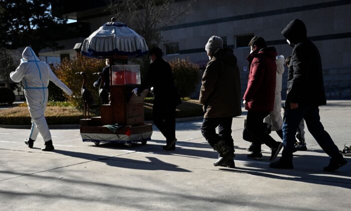 Члены семьи следуют за урной с прахом близкого человека в крематории в Пекине 22 декабря 2022 года. (STF/AFP via Getty Images)
 | Epoch Times Россия