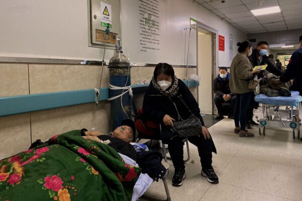 Пациент с COVID-19 лежит на кровати в коридоре больницы Гунжэнь в городе Таншань на северо-востоке Китая, 30 декабря 2022 года. (Noel Celis/AFP via Getty Images)