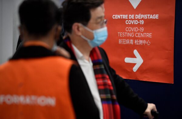 Путешественники рейса из Китая входят в центр тестирования COVID-19 в аэропорту Париж — Шарль-де-Голль в Руасси, 1 января 2023 года. (Julien De Rosa/AFP via Getty Images)