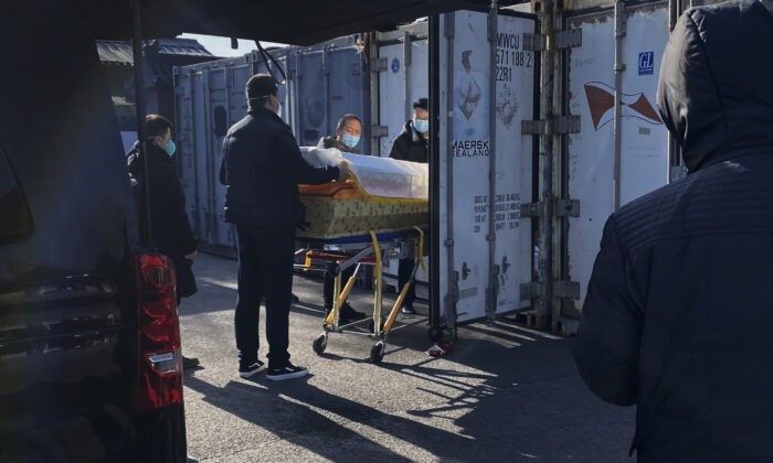 Гроб загружают с катафалка в контейнер для хранения в крематории и похоронном бюро Дунцзяо, одном из нескольких в городе, который занимается случаями COVID-19, в Пекине, Китай, 18 декабря 2022 года. (Getty Images)
 | Epoch Times Россия