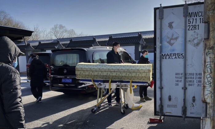 Гроб загружают с катафалка в контейнер для ожидания своей очереди в крематории похоронного бюро Дунцзяо, где кремируют умерших от COVID-19, в Пекине, 18 декабря 2022 года. (Getty Images)
 | Epoch Times Россия