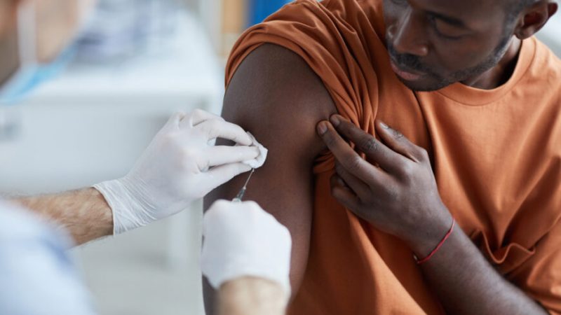 Медсестра вводит вакцину в плечо афроамериканца. (Shutterstock) | Epoch Times Россия