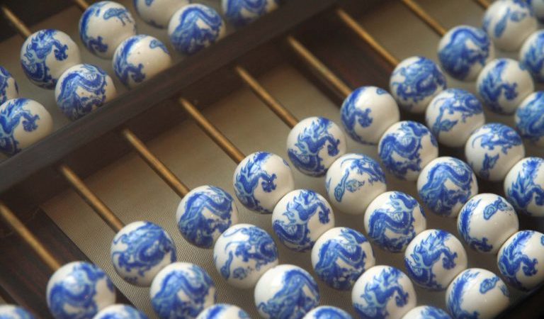 Китайские счёты с фарфоровыми жемчужинами, украшенными голубыми драконами. (Jessica Blanc via Dreamstime) | Epoch Times Россия