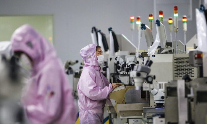 Китайские рабочие в масках и защитных костюмах работают на линии по производству смарт-чипов в Сихонге в восточной китайской провинции Цзянсу, 16 февраля 2020 года. (STR/AFP)
 | Epoch Times Россия