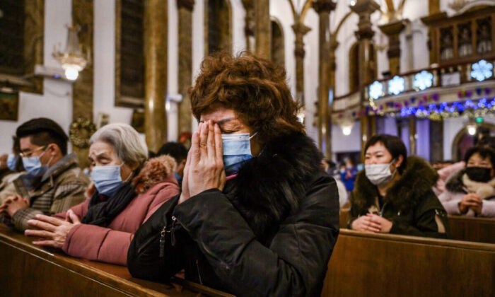 Китайские христиане, сбежавшие в Таиланд, просят убежища в США, опасаясь депортации Китайские христиане молятся во время рождественской мессы в католической церкви в Пекине 24 декабря 2020 года. (Kevin Frayer/Getty Images)