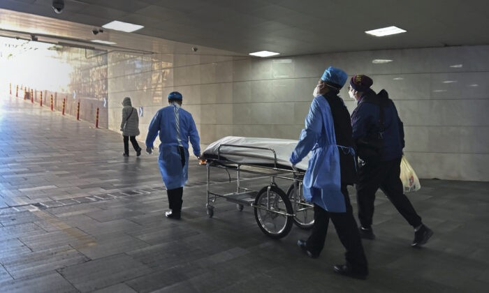 Работники больницы и родственник вывозят тело на каталке из загруженного отделения неотложной помощи в больнице в Пекине, Китай, 2 января 2023 года. (Getty Images)
 | Epoch Times Россия