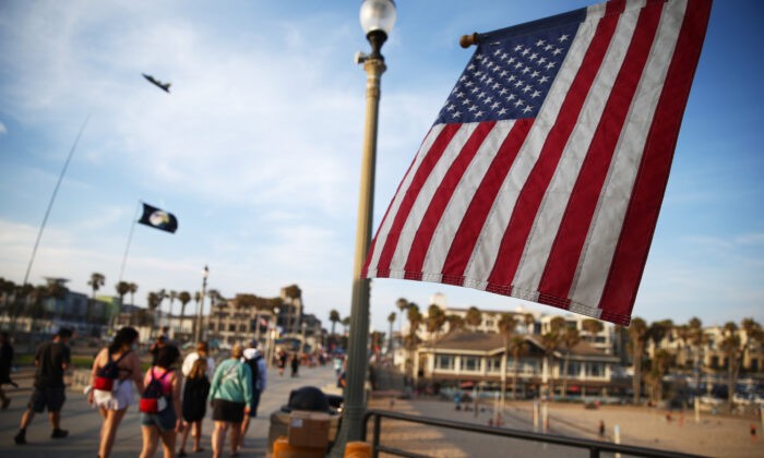 Американский флаг развевается на пирсе Хантингтон-Бич, Калифорния 15 июня 2021 года. Калифорния — первый штат в США, который ввёл карантин в начале пандемии коронавируса. (Mario Tama/Getty Images) | Epoch Times Россия