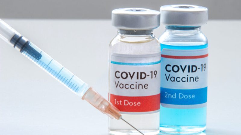 1st dosis and a 2nd dosis of covid-19 vaccine on a vial bottle and injection Syringe on a white table | Epoch Times Россия