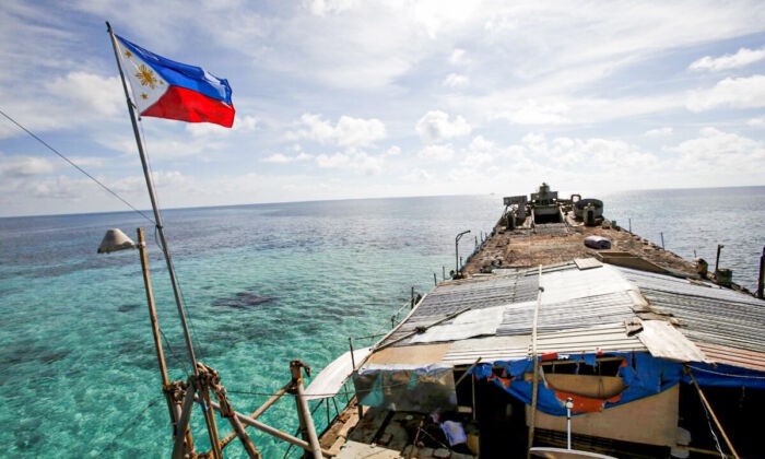 Филиппинский флаг развевается над BRP Sierra Madre, ветхим кораблём филиппинских ВМС, который в 1999 году сел на мель и с тех пор является филиппинским военным форпостом на спорной Второй отмели Томаса, являющейся частью островов Спратли, в Южно-Китайском море, 29 марта 2014 года. (Erik De Castro/Reuters)
 | Epoch Times Россия