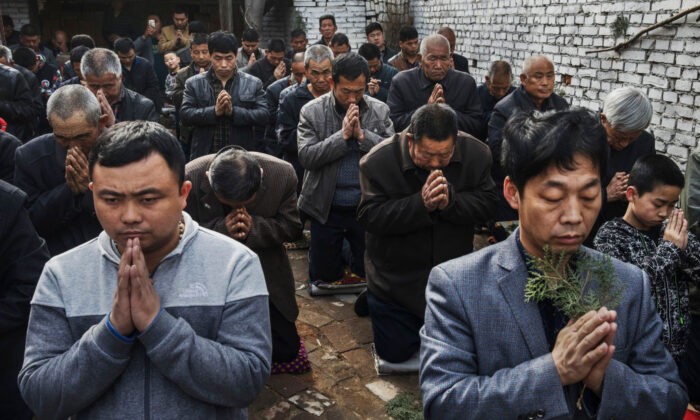 Китайские верующие-католики молятся во время мессы в Вербное воскресенье во время Страстной пасхальной недели в «подпольной» или «неофициальной» церкви недалеко от Шицзячжуана, провинция Хэбэй, Китай, 9 апреля 2017 года. (Kevin Frayer/Getty Images) | Epoch Times Россия