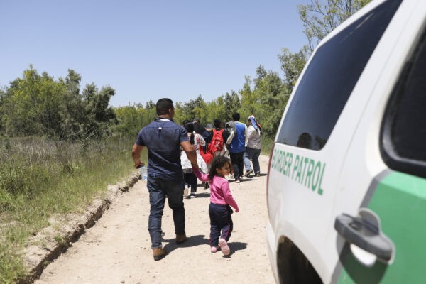 Группа нелегалов идёт по дороге после пересечения Рио-Гранде из Мексики. Далее по дороге они сядут в автобус, направляющийся в пункт обработки пограничного патруля в Макаллене, штат Техас, 18 апреля 2019 года. (Charlotte Cuthbertson/The Epoch Times)
