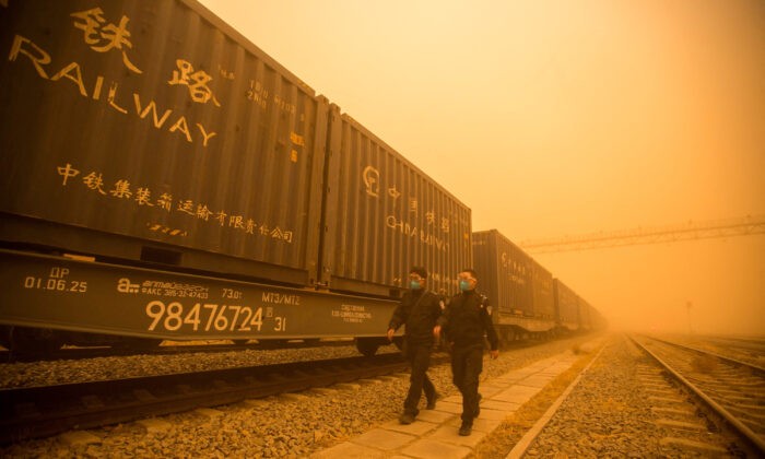 Полицейские проверяют грузовые поезда во время песчаной бури на пограничном контрольно-пропускном пункте в Эренхоте, Внутренняя Монголия, Китай, 21 марта 2023 г. (cnsphoto via Reuters)
 | Epoch Times Россия