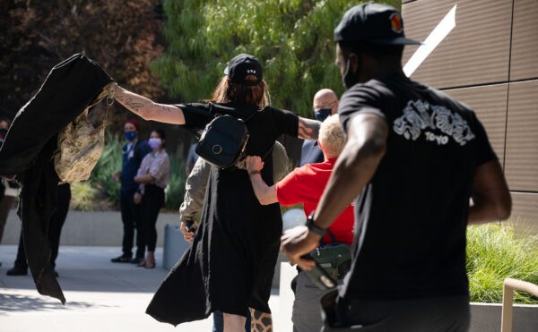 Трансгендерный член «Антифа» нападает на гей-активиста с табличками, сообщающими о свободе слова, в Лос-Анджелесе, Калифорния, 10 октября 2021 г. (John Fredricks/The Epoch Times)