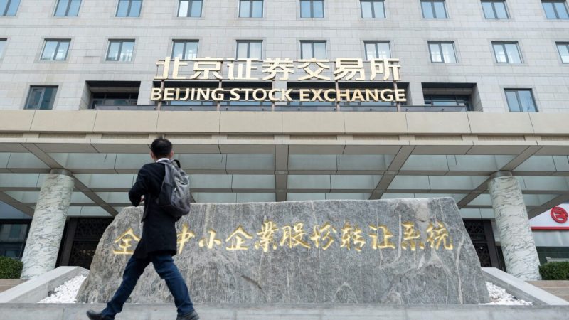 Юань обесценивается Мужчина проходит мимо Пекинской фондовой биржи в первый день торгов в Пекине 15 ноября 2021 года. (Wang Zhao/AFP via Getty Images) | Epoch Times Россия