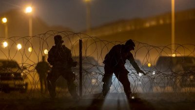 Войска Национальной гвардии Техаса установили колючую проволоку против сотен иммигрантов, которые въехали в Соединённые Штаты из Мексики 9 мая 2023 года в Эль-Пасо, штат Техас. (John Moore/Getty Images)