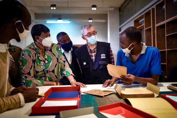 Заместитель директора ЮНЕСКО Син Цю (2-й справа) рассматривает древние рукописи 31 марта 2021 г. (MICHELE CATTANI/AFP via Getty Images)