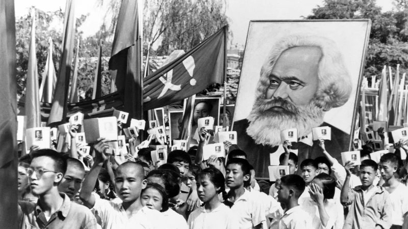 Китайские СМИ призывают начать кампанию против «правых уклонистов новой эпохи», нацеленную на богатых Молодые люди на митинге размахивают «Маленькой красной книгой» Мао и несут портрет Карла Маркса, 14 сентября 1966 года. «Культурная революция» положила начало десятилетию насилия и беспорядков, направленных на достижение коммунистических целей и внедрение радикального эгалитаризма. (AP Photo)