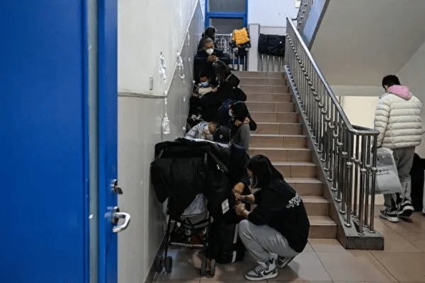 Детям ставят капельницы на лестнице в детской больнице в Пекине 23 ноября 2023 года. (Jade Gao /AFP via Getty Images)