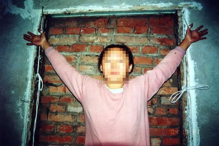 Инсценировка пытки путём подвешивания на верёвке, обвязанной вокруг больших пальцев. (Courtesy of Minghui.org)