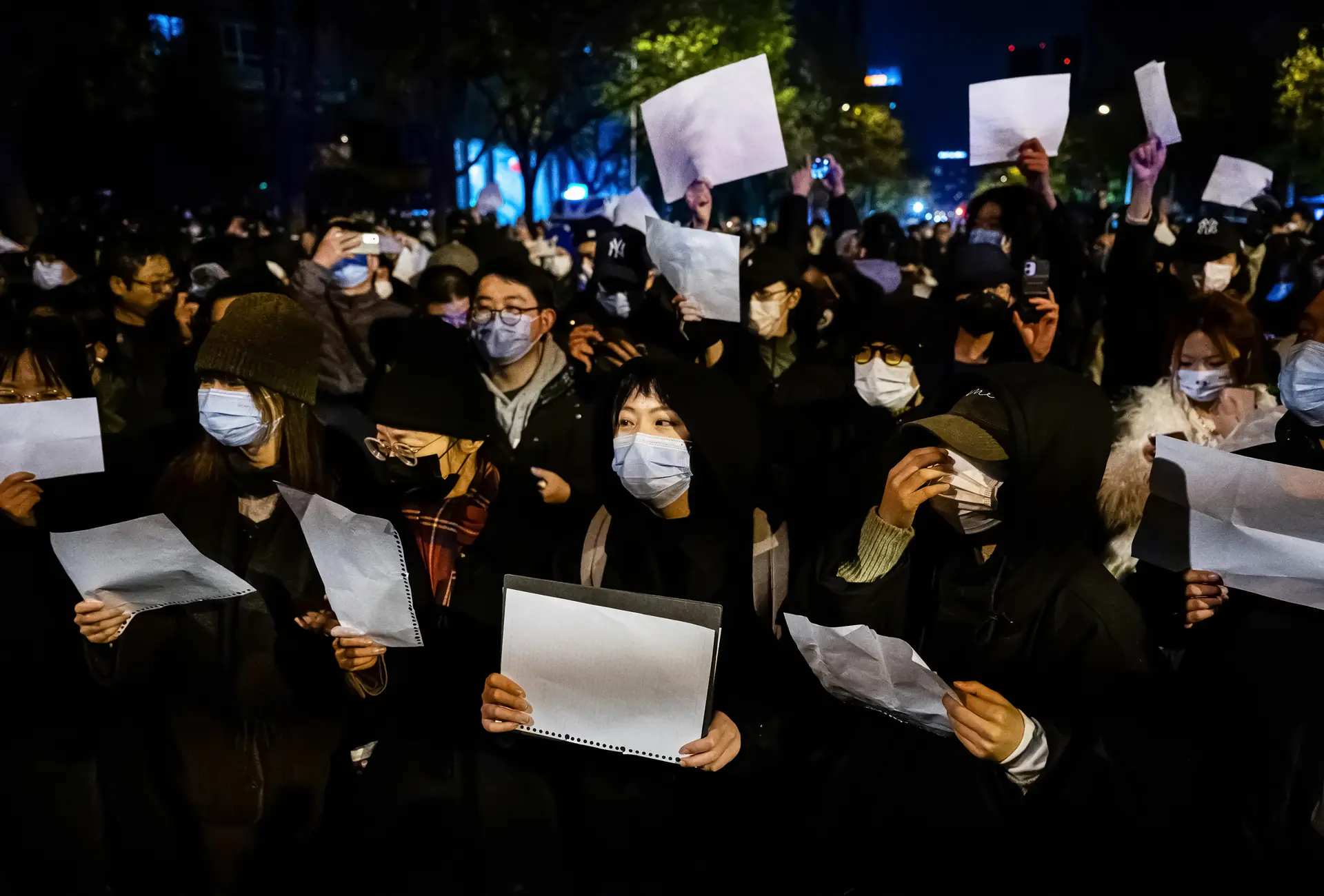 Люди держат в руках чистые листы бумаги в знак протеста против строгих карантинов COVID-19 в Пекине 27 ноября 2022 года. (Kevin Frayer/Getty Images) «Вам не избежать его когтей»: длинная рука Пекина нацелена на студентов