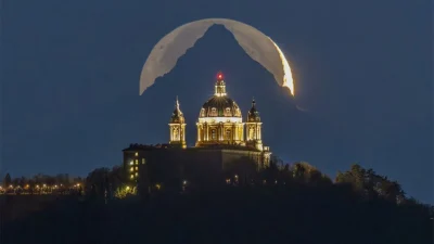 Фотография собора, горы и луны будто сделана в фантастическом мире