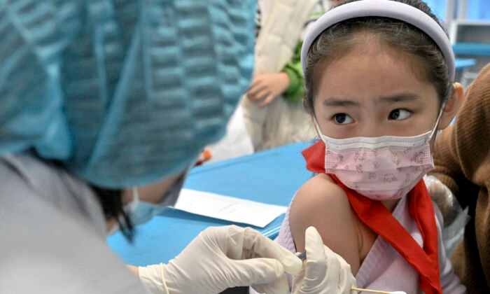 Ребёнок получает вакцину против коронавируса COVID-19 в школе в Хандане в северной китайской провинции Хэбэй, 27 октября 2021 года. (AFP via Getty Images)
 | Epoch Times Россия