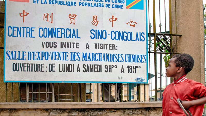Конголезский мальчик смотрит на вывеску, рекламирующую торговый центр, торгующий китайскими товарами, в Киншасе, Демократическая Республика Конго, 3 ноября 2006 года. (Lionel Healing/AFP via Getty Images) | Epoch Times Россия