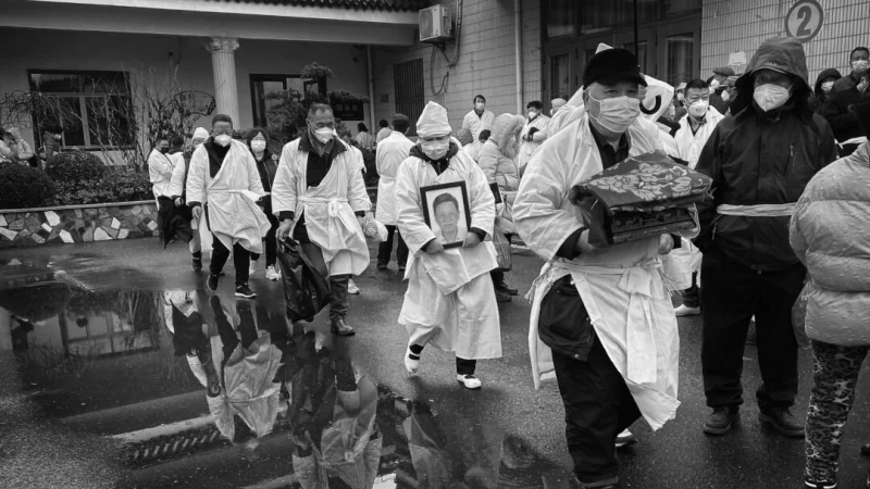 Люди в традиционной белой одежде несут кремированные останки родственников в Шанхае, Китай, 14 января 2023 года. (Kevin Frayer/Getty Images) | Epoch Times Россия