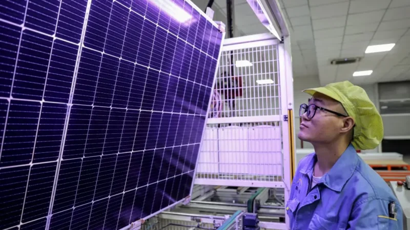 Рабочий, производящий солнечные фотоэлектрические модули, используемые для солнечных панелей, в мастерской в Хуайане, провинция Цзянсу, Китай, 25 сентября 2023 года. (STR/AFP via Getty Images) | Epoch Times Россия