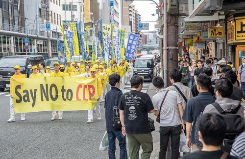 Практикующие провели парад в Осаке во второй половине дня 14 июля. (Фото: minghui.org) Кансай, Япония. Парады в Осаке и Киото разоблачают преследование Фалунь Дафа компартией Китая