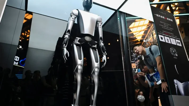 Посетители наблюдают за роботом Tesla, представленным на Всемирной конференции по искусственному интеллекту (WAIC) в Шанхае 6 июля 2023 года. (Wang Zhao/AFP via Getty Images) | Epoch Times Россия