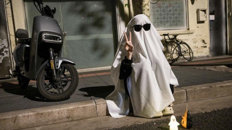 Человек в костюме, сидящий на улице в преддверии Хэллоуина в Шанхае, Китай, 30 октября 2023 года. (STR/AFP via Getty Images) | Epoch Times Россия