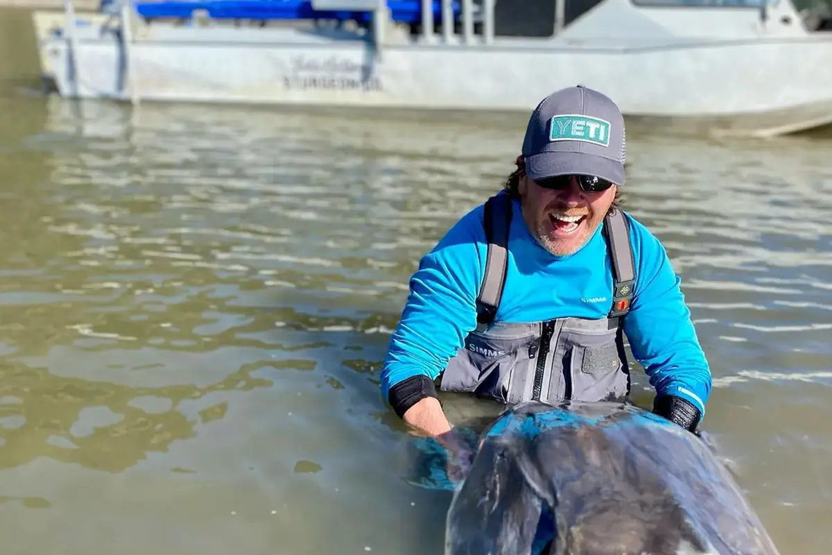 Ив Биссон во время предыдущей экскурсии ловит гигантского осетра на реке Фрейзер. (Courtesy of Yves Bisson) Биолог выловил 230-килограммового осетра на реке Фрейзер в Канаде