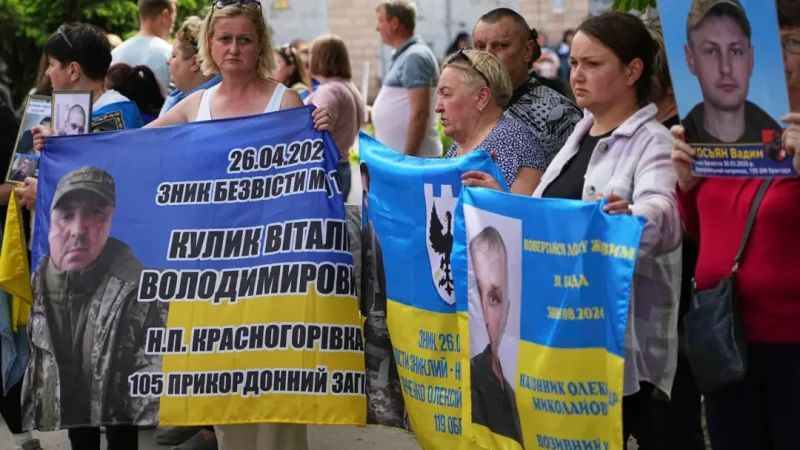 Члены семей украинских военнопленных держат плакаты и фотографии военнослужащих, находящихся в плену, в преддверии обмена пленными между Россией и Украиной, Черниговская область, Украина, 23 мая 2025 года. (Efrem Lukatsky/AP Photo)